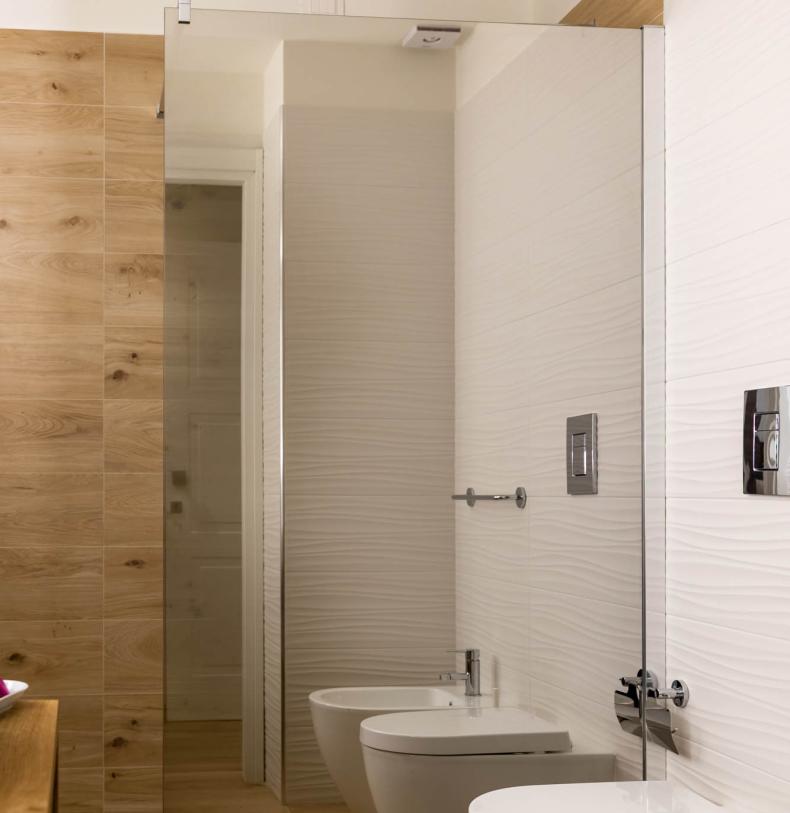 Bagno moderno con legno e ceramica, bidet e WC.