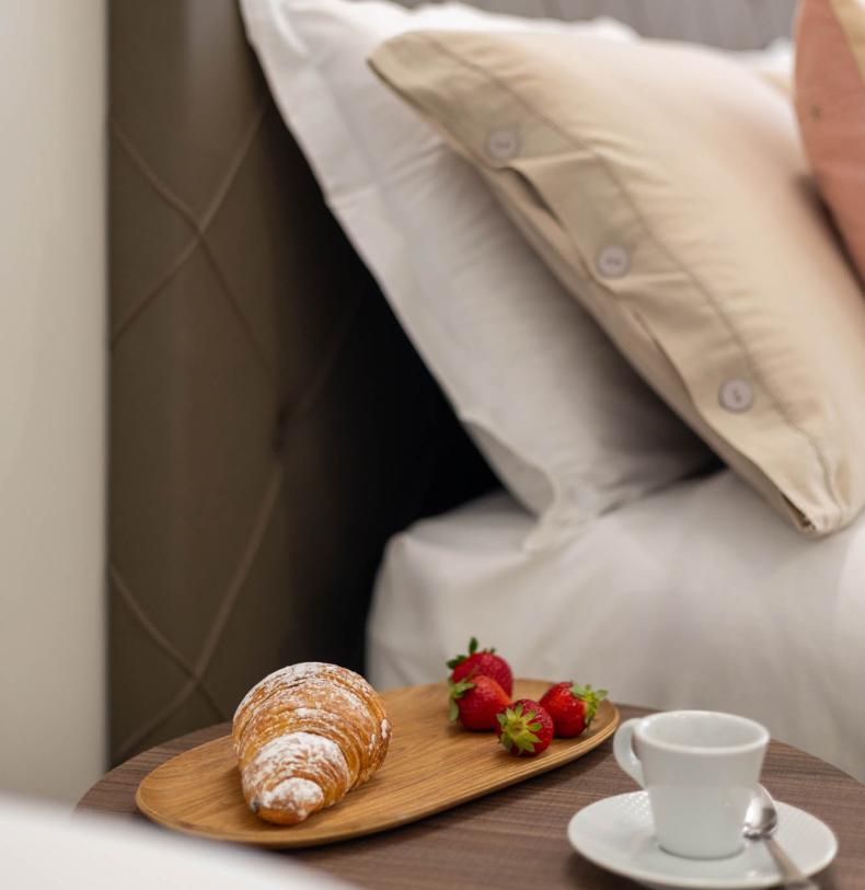 Colazione a letto con croissant, fragole e caffè.