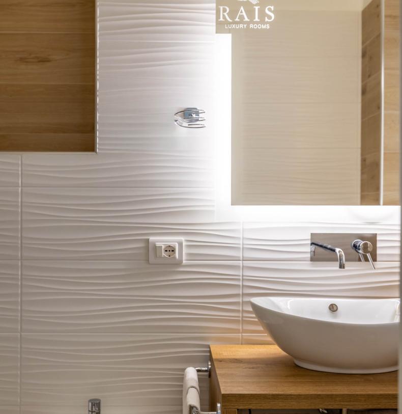 Elegante bagno con lavabo moderno e pareti ondulate.